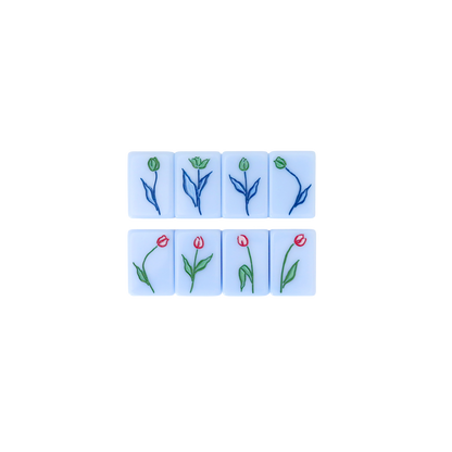 Kayce Hughes mahjong flower tiles close-up: eight flower tiles with hand-drawn tulips in red, green and blue on soft blue acrylic